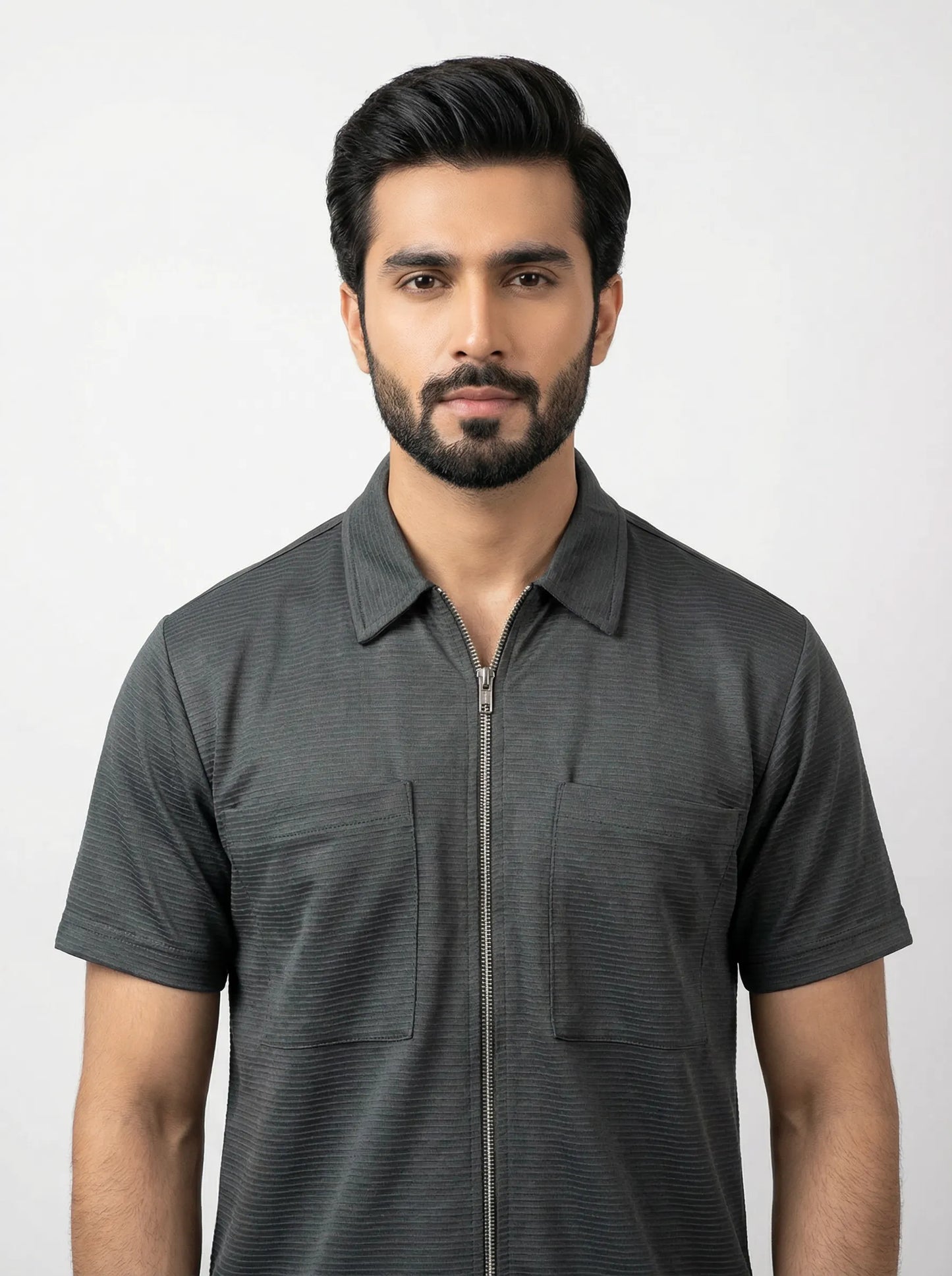 Man wearing a dark gray short-sleeve shirt with a collar on a white background