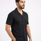 Man wearing a black short-sleeve shirt on a white background