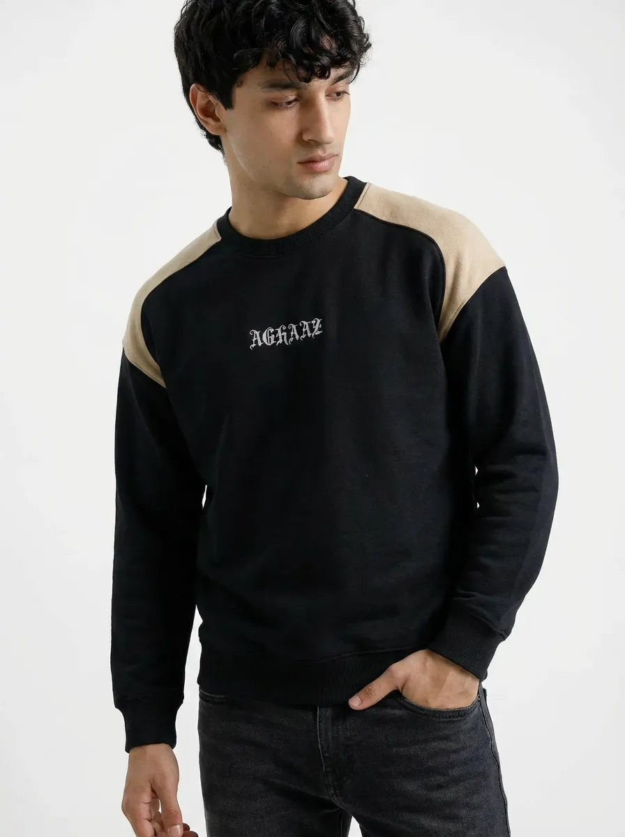 Person wearing a black and beige sweatshirt with 'Aghaz' branding on a white background