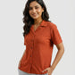 Woman wearing a rust-colored short-sleeve shirt on a white background