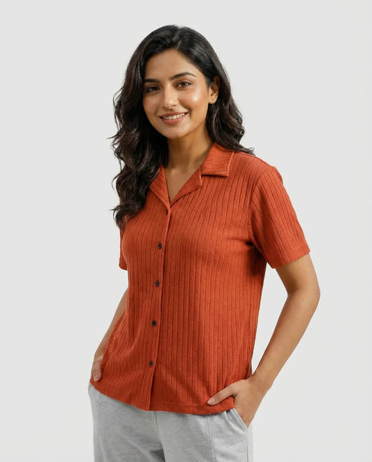 Woman wearing a rust-colored short-sleeve shirt on a white background