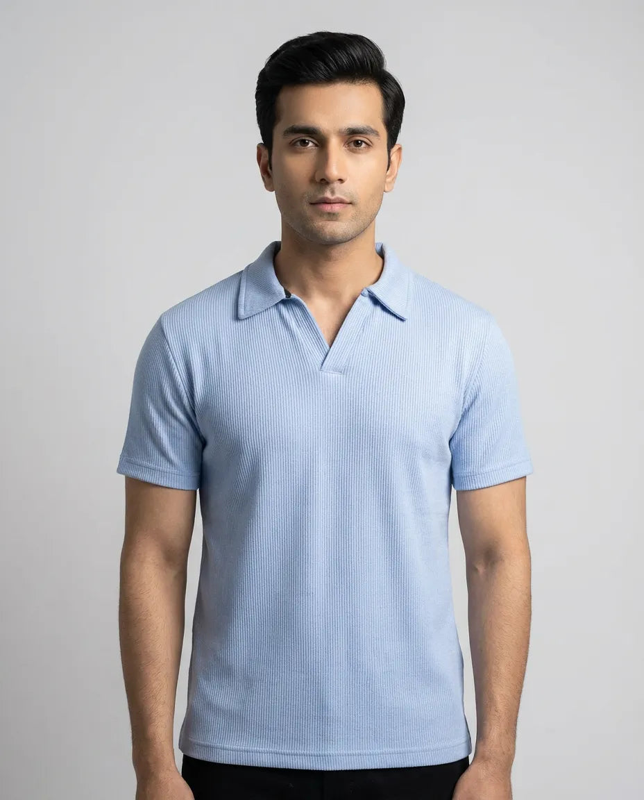 Man wearing a light blue polo shirt against a gray background