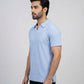 Man wearing a light blue polo shirt against a gray background
