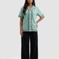 Woman wearing a light green shirt with black pants on a white background